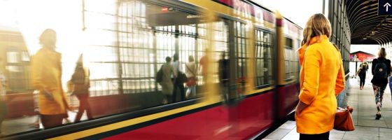 Frau steht vor einfahrender S-Bahn