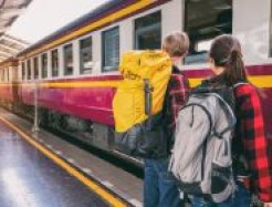 Menschen warten vor einem Zug