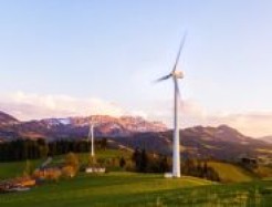Zwei Windräder in einer Berglandschaft