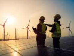 zwei Menschen planen Energiewende inmitten eines Solar- und Windparks