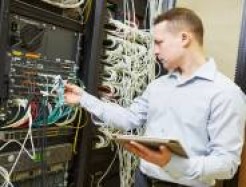 Person in einem Rechenzentrum prüft die Kabel 