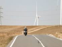 Motorrad auf Landstraße zwischen Windrad